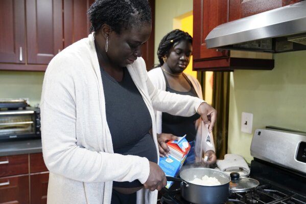 Ebele Azikiwe, 12, right, cooks with her mother, Rume Joy Azikiwe-Oyeyemi, at home in Cherry Hill, N.J., Wednesday, March 24, 2021. Ebele testified in October at state Assembly hearing, lending her support to legislation requiring New Jersey's school districts to add diversity to curriculums. Democratic Gov. Phil Murphy signed the bill into law. (AP Photo/Matt Rourke)