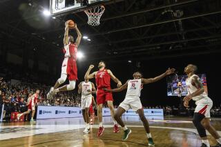 Canada's Jean-Victor Mukama (8) dunks as teammate Owen Klassen (4) and Panama's Eric Romero (16) react during second-half FIBA World Cup qualifiers basketball game action in Edmonton, Alberta, Sunday, Nov. 13, 2022. (Jason Franson/The Canadian Press via AP)