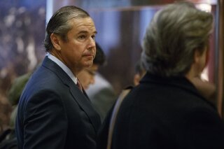 FILE - In this Nov. 30, 2016, file photo, investor Ray Washburne waits for an elevator in the lobby of Trump Tower in New York. As much as $273 million in federal coronavirus aid was awarded to more than 100 companies that are owned or operated by major donors to President Donald Trump's election efforts, according to an Associated Press analysis of federal data that was released Monday, July 6, 2020. Irving, Texas-based M Crowd Restaurant Group, which owns 27 Texas restaurants including the Mi Cocina chain, was approved for between $5 million and $10 million. Washburne, one of the company’s founders, was vice chairman of the Trump Victory Committee in 2016 and donated $100,000 to the PAC last August. The company did not respond to a request for comment. (AP Photo/Evan Vucci, File)