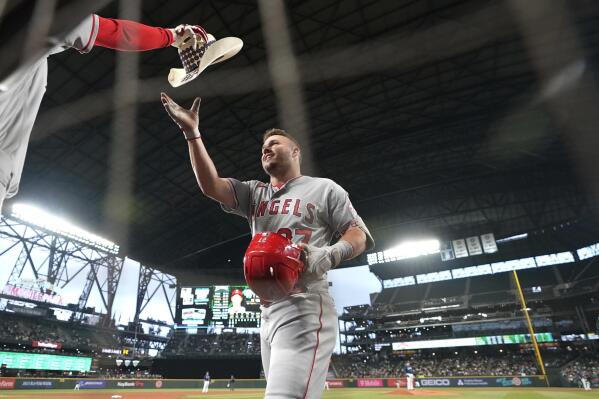 Los Angeles Angels' Mike Trout reaches for a cowboy hat as he walks to the dugout after hitting a solo home run against the Seattle Mariners during the third inning of the second baseball game of a doubleheader Saturday, June 18, 2022, in Seattle. (AP Photo/Ted S. Warren)