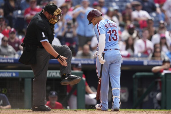 Philadelphia Phillies' Rafael Marchán, right, and umpire Bruce Dreckman react after Marchán was hit by a pitch from Atlanta Braves' Daysbel Hernández with the bases loaded during the eighth inning in the first baseball game of a doubleheader Thursday, May 29, 2025, in Philadelphia. (AP Photo/Matt Slocum)