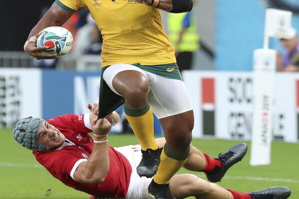 FILE - In this Sept. 29, 2019 file photo, Australia's Samu Kerevi is tackled by Wales' Jonathan Davies during the Rugby World Cup Pool D game at Tokyo Stadium between Australia and Wales in Tokyo, Japan. Kerevi has been named in the Australian 7's squad for the Tokyo Olympics. (AP Photo/Eugene Hoshiko,File)