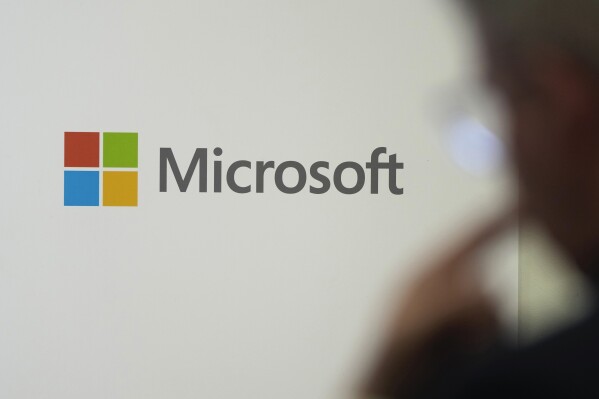 The Microsoft logo is displayed at an event at the Chatham House think tank in London, Monday, Jan. 15, 2024. Microsoft's Copilot lets users ask software to perform tasks like summarize an email or a Teams meeting, come up with key themes in a document, or draft emails in a conversational tone in Outlook.(AP Photo/Kin Cheung)