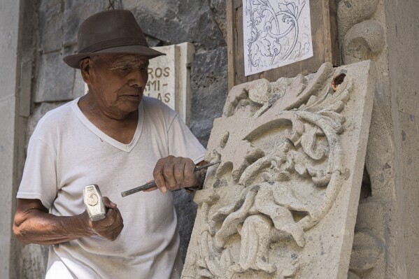 Master stone carver Tomás Ugarte sculpts quarry at the cemetery in the Mexico City borough of Chilmalhuacan, once the ancient village of Xochiaca, Sunday, July 2, 2023. Ugarte learned in the traditional way to carve stone as handed down by fathers and grandfathers, dating back about five generations. (AP Photo/Aurea Del Rosario)