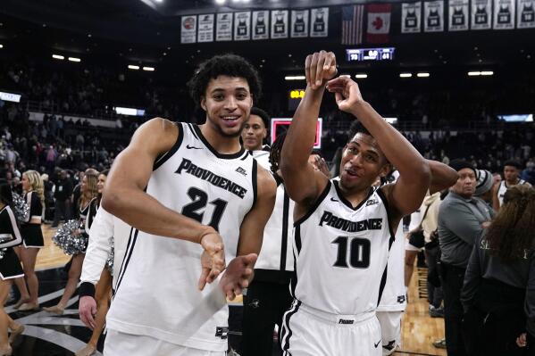 Providence guard Noah Locke (10) and forward Clifton Moore (21) celebrate the team's win over UConn in an NCAA college basketball game, Wednesday, Jan. 4, 2023, in Providence, R.I. Providence won 73-61. (AP Photo/Charles Krupa)