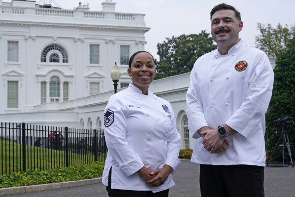 Air Force Master Sgt. and chef Opal Poullard, left, and Marine Corps Gunnery Sgt. and chef Dustin Lewis, right, pose for a photo at the White House in Washington, Friday, June 30, 2023. Poullard and Lewis were crowned "Chopped" champions during first lady Jill Biden's appearance on the season finale of the Food Network's Chopped "Military Salute." They will serve as guest chefs at the White House Navy Mess ahead of the 4th of July holiday. (AP Photo/Susan Walsh)
