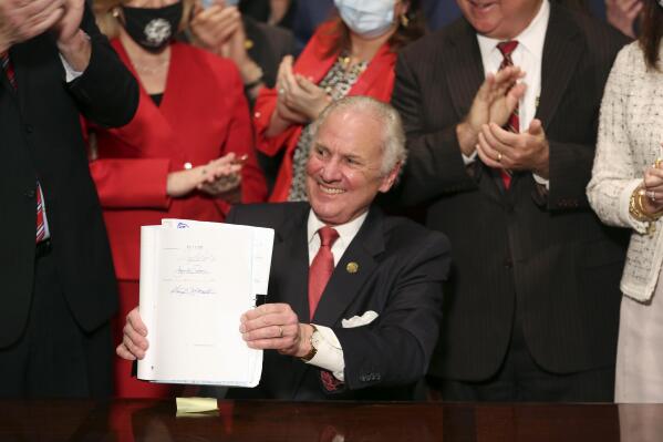 FILE - South Carolina Gov. Henry McMaster holds up a bill banning almost all abortions in the state after he signed it into law on Feb. 18, 2021, in Columbia, S.C. The South Carolina ban on abortions after cardiac activity is no more after the latest legal challenge to the state’s 2021 law proved successful. The state Supreme Court ruled Thursday, Jan. 5, 2023, that the restrictions violate the state constitution’s right to privacy. (AP Photo/Jeffrey Collins, File)