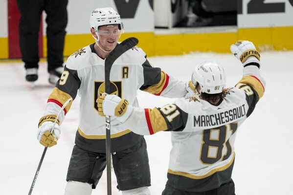 Vegas Golden Knights center Jack Eichel, left, celebrates his empty net goal with Jonathan Marchessault (81) during the third period in Game 2 of an NHL hockey Stanley Cup first-round playoff series against the Dallas Stars in Dallas, Wednesday, April 24, 2024. (AP Photo/Tony Gutierrez)