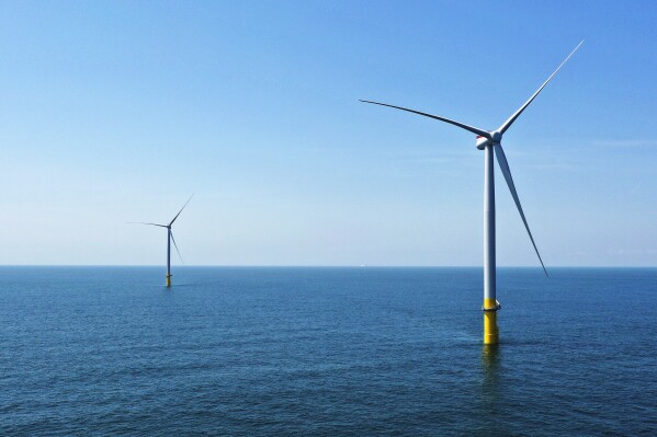 FILE - Two of the Siemens Gamesa offshore wind turbines stand off the coast of Virginia Beach, Va., Monday, June 29, 2020. The German government says it is granting a 7.5 billion-euro ($8 billion) loan guarantee to energy technology company Siemens Energy as part of a package to help the firm, an important player in the transition to renewable energy sources. Siemens Energy sought help from the government as it struggles with problems at its Gamesa wind energy subsidiary (AP Photo/Steve Helber, File)