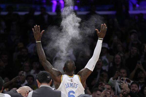 Los Angeles Lakers forward LeBron James tosses powder in the air prior to an NBA basketball game against the Golden State Warriors Thursday, Feb. 23, 2023, in Los Angeles. (AP Photo/Mark J. Terrill)