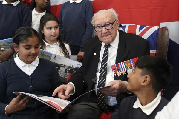 D-Day veteran and Ambassador for the British Normandy Memorial, Ken Hay, 98, who served with the 4th Dorset Regiment, speaks to children during a visit to Rush Green Primary School in Dagenham, England, Monday May 20, 2024, ahead of the 80th anniversary of the D-Day landings. (Gareth Fuller/PA via AP)