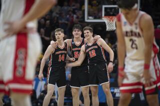 Princeton guard Matt Allocco (14) forward Zach Martini (54) and forward Caden Pierce (12) and teammates embrace in the final seconds of the second half of a first-round college basketball game against Arizona in the NCAA Tournament in Sacramento, Calif., Thursday, March 16, 2023. Princeton won 59-55. (AP Photo/José Luis Villegas)