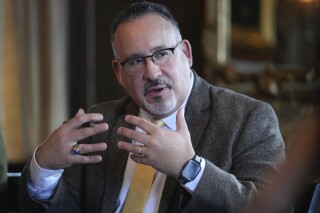 FILE - Education Secretary Miguel Cardona participates in a roundtable discussion with students from Dartmouth College, Jan. 10, 2024. After months of delays and technical hiccups, some colleges and universities have started to receive federal data they need to put together financial aid offers for incoming students. (AP Photo/Steven Senne)