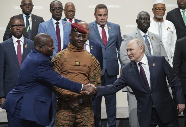 Russian President Vladimir Putin, right, and Mozambique President Filipe Nyusi shake hands during a family photo opportunity during the Russia Africa Summit in St. Petersburg, Russia, Friday, July 28, 2023. (Alexei Danichev, Sputnik, Kremlin Pool Photo via AP)