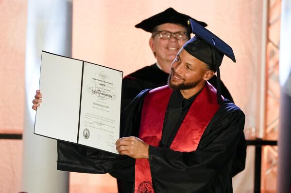 Golden State Warriors Stephen Curry poses with his diploma after his graduation ceremony at Davidson College on Wednesday, Aug. 31, 2022, in Davidson, N.C. Curry was also inducted into the school's Hall of Fame and his number and jersey were retired during the event. (AP Photo/Chris Carlson)