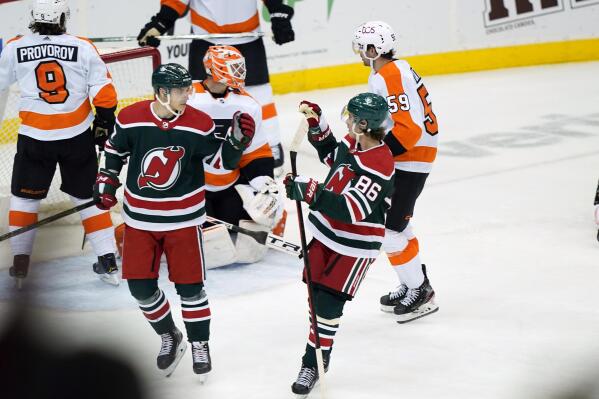 New Jersey Devils center Jack Hughes (86) congratulates Devils center Yegor Sharangovich, second from left, after Sharagovich scored the go-ahead goal against Philadelphia Flyers goaltender Brian Elliott, third from left, during the third period of an NHL hockey game, Tuesday, April 27, 2021, in Newark, N.J., in the Devils victory over the Flyers. (AP Photo/Kathy Willens)