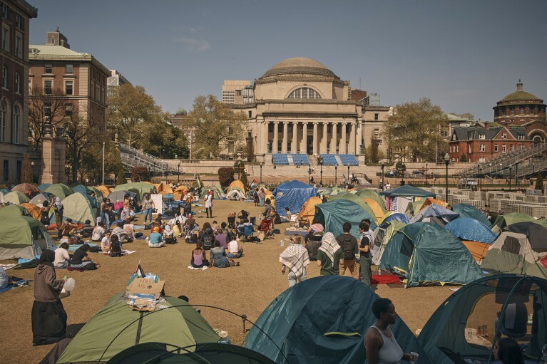 People listen to a speaker at a pro-Palestinian encampment, advocating for financial disclosure and divestment from all companies tied to Israel and calling for a permanent cease-fire in Gaza, at Columbia University on Sunday, April 28, 2024, in New York. (AP Photo/Andres Kudacki)