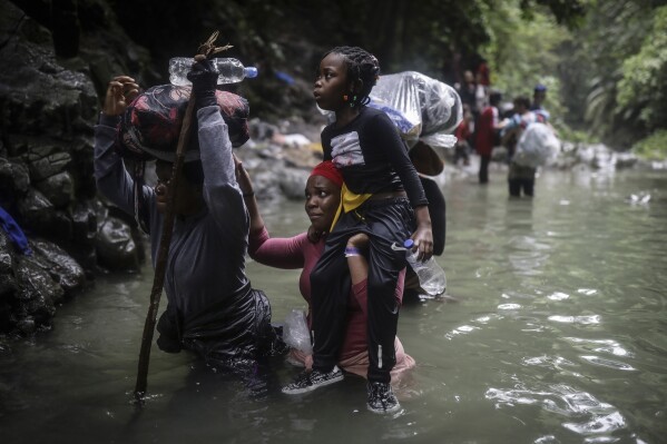 FILE - Haitian migrants wade through water as they cross the Darien Gap from Colombia to Panama in hopes of reaching the United States, May 9, 2023. Colombia and Panama are failing to protect hundreds of thousands of migrants who are crossing the Darien jungle on their way to the U.S. and have become increasingly vulnerable to robberies and sexual violence, Human Rights Watch said in a report published Wednesday, April 3, 2024. (AP Photo/Ivan Valencia, File)
