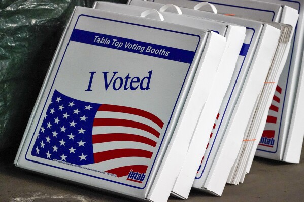 FILE - Table top voting booths are stored at the Allegheny County Election Division warehouse on the Northside of Pittsburgh, Friday, Nov. 6, 2020. New data from automatic voter registration at Pennsylvania driver’s license centers shows that sign-ups have grown but remain almost evenly divided between the political parties in the presidential battleground state. (AP Photo/Gene J. Puskar, File)