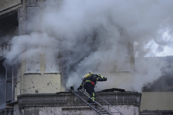A firefighter gestures as he prepares to enter a building at the site after a Russian attack in Kyiv, Ukraine, Thursday, March 21, 2024. Around 30 cruise and ballistic missiles were shot down over Kyiv on Thursday morning, said Serhii Popko, the head of Kyiv City Administration. The missiles were entering Kyiv simultaneously from various directions in a first missile attack on the capital in 44 days. (AP Photo/Vadim Ghirda)
