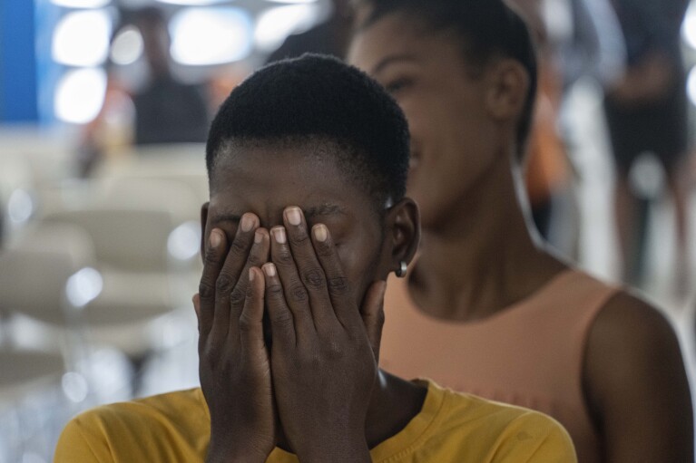 Una mujer se cubre la cara como parte de un ejercicio durante una clase para adultos sobre cómo ayudar a los niños a superar el trauma y el miedo en medio de la violencia, en Puerto Príncipe, Haití, el domingo 5 de mayo de 2024. A medida que los jóvenes haitianos están cada vez más expuestos a violencia, el país está realizando un esfuerzo más amplio para disipar un tabú de larga data sobre buscar terapia y hablar sobre salud mental. (Foto AP/Ramón Espinosa)