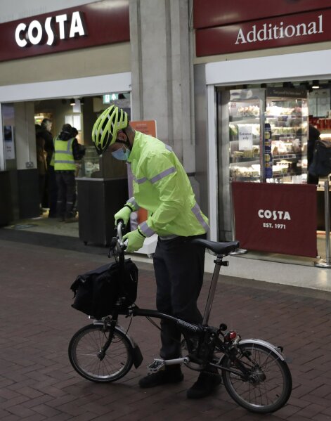 A man unfolds a Brompton folding bicycle as he leaves Waterloo Station, in London, during England...