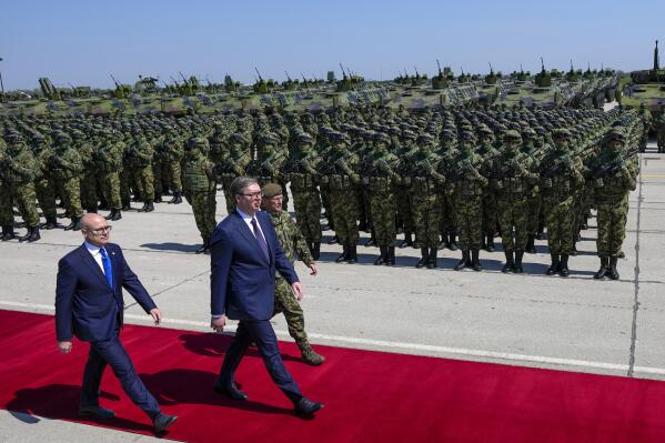 Serbian President Aleksandar Vucic, center, reviews the honor guard during a welcome ceremony before the military exercises at Batajnica military airport near Belgrade, Serbia, Saturday, April 22, 2023. The populist leaders of Serbia and Hungary observed a Serbian military exercise Saturday, an event seen as a display of lethal firepower amid the war in Ukraine and tensions in the Balkans. (AP Photo/Darko Vojinovic)