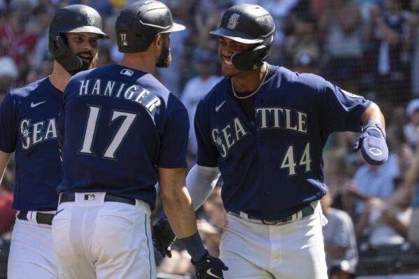 Seattle Mariners' Mitch Haniger, center, is congratulated by Jesse Winker, left, and Julio Rodriguez after hitting a three-run home run off Cleveland Guardians starting pitcher Triston McKenzie during the first inning of a baseball game, Thursday, Aug. 25, 2022, in Seattle. (AP Photo/Stephen Brashear)