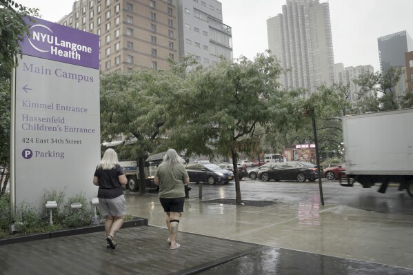 Mary Miller-Duffy and her wife, Sue Duffy, leave the NYU Langone Health medical center in New York on Aug. 10, 2023. Research with her brother-in-law's body has changed Sue's outlook on organ donation. “Maybe I don’t need all my organs when I go to heaven,” she says. “Before I was a hard no. ... Now I’m a hard yes.” (AP Photo/Shelby Lum)