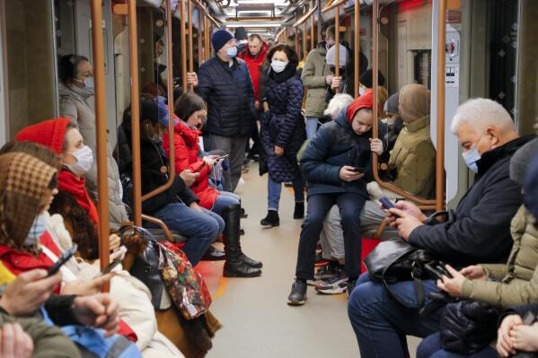 People ride a subway carriage as some of them read on their smartphones in Moscow, Russia, Thursday, Feb. 24, 2022. (AP Photo/Alexander Zemlianichenko Jr)