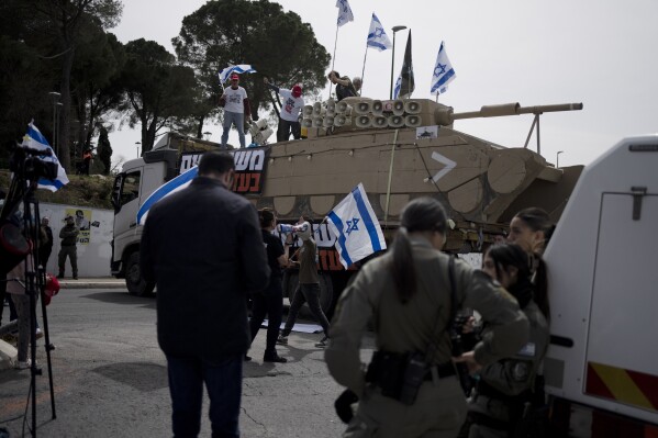 Membros da organização Irmãos e Irmãs de Armas protestam contra as isenções de Israel para judeus ultraortodoxos do serviço militar obrigatório, perto do Gabinete do Primeiro Ministro em Jerusalém, terça-feira, 26 de março de 2024. (AP Photo/Maya Alleruzzo)