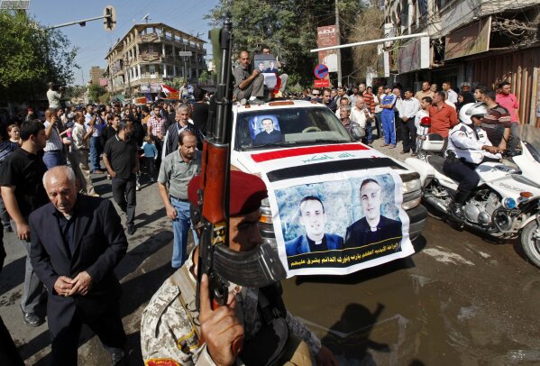 File - In this Tuesday, Nov. 2, 2010 file photo, the coffins of two slain priests and their parishioners arrive at a funeral mass in Baghdad, Iraq. The victims were killed Sunday when gunmen stormed a church during mass and took the entire congregation hostage. The attack, claimed by an al-Qaida-linked organization, was the deadliest recorded against Iraq's Christians since the 2003 U.S.-led invasion unleashed a wave of violence against them. The text on the banner, in Arabic, reads "Please, God, give him eternal rest and make your light shine on him." (AP Photo/Hadi Mizban, File)