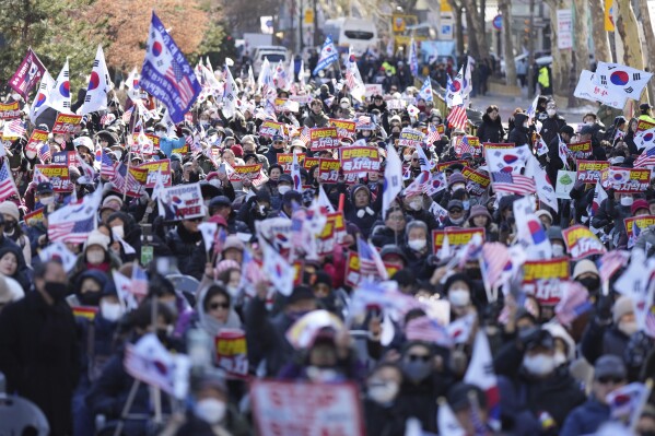 Supporters of impeached South Korean President Yoon Suk Yeol hold signs during a rally to oppose his impeachment near the Constitutional Court in Seoul, South Korea, Thursday, Feb. 13, 2025. The letters read "Nullity Impeachment" (AP Photo/Lee Jin-man)