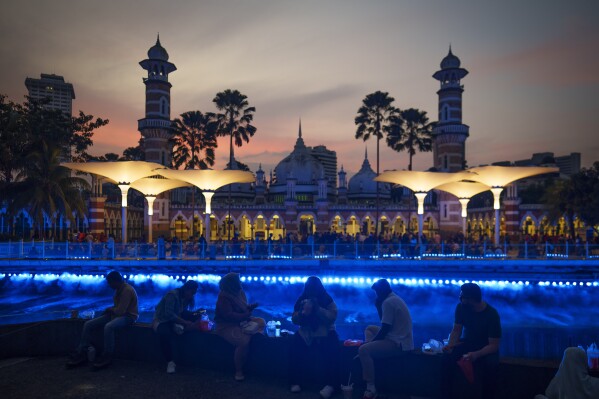 Muslims eat during Iftar, the sunset meal when Muslims break their fast in the holy month of Ramadan at a mosque in Kuala Lumpur, Malaysia, Tuesday, March 12, 2024. (AP Photo/Vincent Thian)
