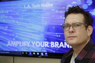 In this Tuesday, Sept. 17, 2019 photo, Gabe Uribe, co-owner of L.A. Tech House, a public relations firm that focuses on tech companies, poses in his office in Beverly Hills, Calif. When he began advertising online, he went with the common wisdom that the more spent on Google ads, the better the results. But he learned he could cut his budget and be fine. "If you put some strategy into it, you have a good chance of going up against the big guys," Uribe says. "We own our little corner with tech PR." (AP Photo/Damian Dovarganes)