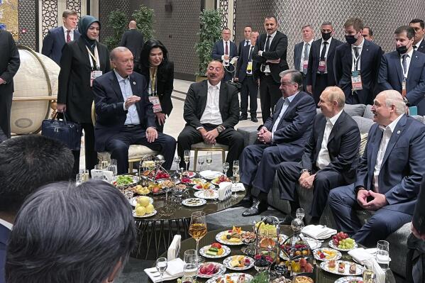 In this photo provided by the Turkish Presidency, Turkey's President Recep Tayyip Erdogan, centre left speaks to Azerbaijani President Ilham Aliyev, Uzbek President Shavkat Mirziyoyev, Russian President Vladimir Putin, Belarusian President Alexander Lukashenko and Iranian President Ebrahim Raisi, at the Shanghai Cooperation Organisation (SCO) summit in Samarkand, Uzbekistan, Thursday, Sept. 15, 2022. (Turkish Presidency via AP)