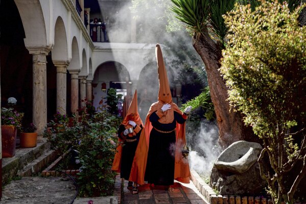 Nazarenes carry incense burners during a Holy Week procession in Tunja, Colombia, Wednesday, April 16, 2025. (AP Photo/Ivan Valencia)