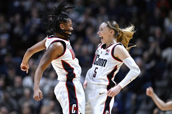 UConn guards KK Arnold, left, and Paige Bueckers, right, celebrate during the first half of an NCAA college basketball game against Georgetown in the finals of the Big East Conference tournament at Mohegan Sun Arena, Monday, March 11, 2024, in Uncasville, Conn. (AP Photo/Jessica Hill)