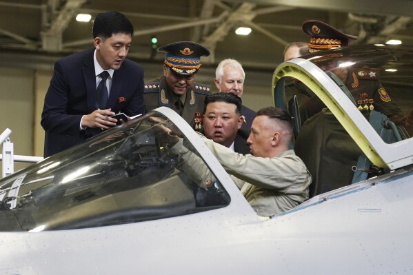 In this photo released by the Khabarovsky Krai region government, North Korean leader Kim Jong Un, center, looks at a military jet cockpit while visiting a Russian aircraft plant that builds fighter jets in Komsomolsk-on-Amur, about 6,200 kilometers (3,900 miles) east of Moscow, Russia, Friday, Sept. 15, 2023. (Khabarovsky Krai region government via AP)