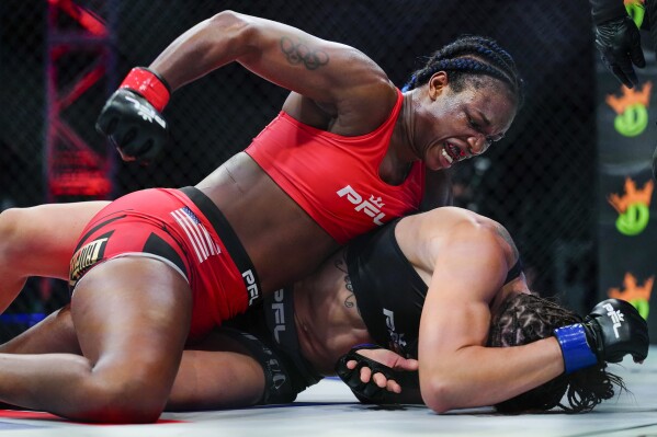 FILE -Claressa Shields, top, punches Brittney Elkin during a Professional Fighters League mixed martial arts bout in Atlantic City, N.J., early Friday, June 11, 2021. Two-time Olympic gold medalist and three-division boxing world champion Claressa Shields is returning for another round of MMA fights. Shields and the Professional Fighters League announced a multi-year agreement on Wednesday, Aug. 9, 2023, and she expects to enter the cage again in 2024 at 158 pounds. (AP Photo/Matt Rourke, File)