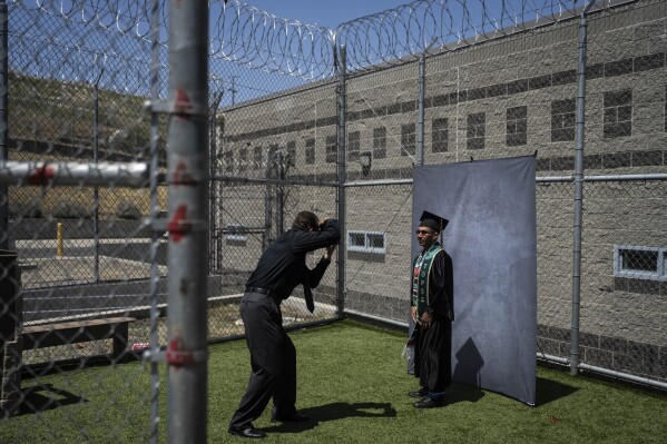 Incarcerated graduate Jose Catalan poses for photos after his graduation ceremony at Folsom State Prison in Folsom, Calif., Thursday, May 25, 2023. Catalan earned his bachelor's degree in communications through the Transforming Outcomes Project at Sacramento State. (AP Photo/Jae C. Hong)