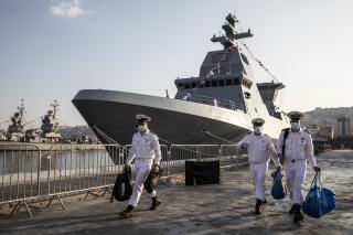 FILE - Israeli sailors walk on a pier near the first of four German-made Sa'ar 6 corvette warships, in Haifa, Israel, Dec. 2, 2020. Israel on Monday, Feb. 21, 2022, said it successfully tested a new naval air defense system, intercepting a series of threats in what officials called a key layer of protection against Iran and its proxies in the region. The “C-Dome” system, a naval version of the Iron Dome, is being installed on Israel's latest-generation corvette warships. (Heidi Levine/Pool Photo via AP, File)