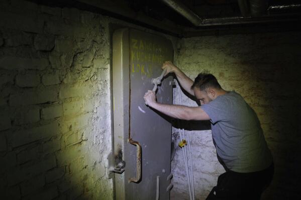 Jacek, 37, a local resident, closes a door to a shelter in the basement of a residential building in Warsaw, Poland, Wednesday, Oct. 19, 2022. Fighting around Ukraine's nuclear power plants and Russia's threats to use nuclear weapons have reawakened nuclear fears in Europe. This is especially felt in countries near Ukraine, like Poland, where the government this month ordered an inventory of the country's shelters as a precaution. (AP Photo/Michal Dyjuk)