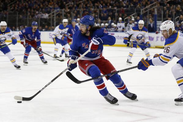 New York Rangers' Mika Zibanejad (93) keeps the puck from Buffalo Sabres' Rasmus Dahlin (26) during the second period of an NHL hockey game Sunday, Nov. 21, 2021, in New York. (AP Photo/John Munson)