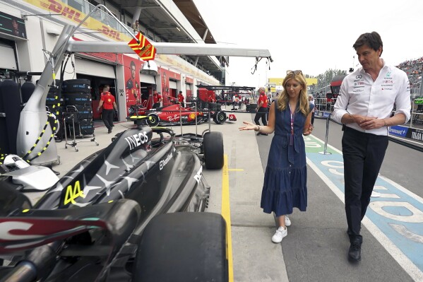 This photo provided by CNBC shows CNBC's Sara Eisen walking outside the garage with Toto Wolff, Mercedes-AMG Petronas F1 Team Principal and CEO, June 16, 2023, at the Canadian Grand Prix in Montreal. CNBC will debut a behind-the-scenes analysis of the business of Formula One on November 16th. The documentary “Inside Track: The Business of Formula 1” will explore the global motorsports series attendance growth, viewership, and market value as it looks ahead to next month’s inaugural Las Vegas Grand Prix.(CNBC via AP)