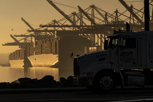 FILE - A truck arrives to pick up a shipping container near vessels at the Port of Los Angeles, on Nov. 30, 2021. An influential government advisory panel comprised of major U.S. businesses is proposing new rules that would roll back already limited public access to import data, a move that trade experts say would make it harder to trace labor abuse by foreign suppliers. The proposal, if adopted, would shroud in secrecy customs data on ocean-going freight responsible for about half of the $2.7 trillion worth of goods entering the U.S. every year in the same way it already is for rail, truck and air cargo. (AP Photo/Damian Dovarganes, File)