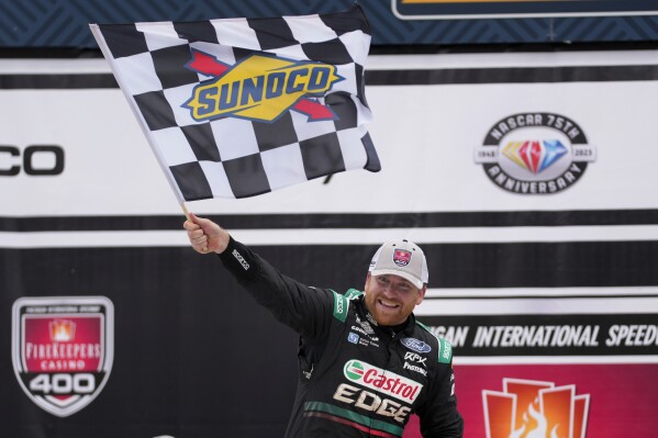 Chris Buescher celebrates his victory during a NASCAR Cup Series auto race at Michigan International Speedway in Brooklyn, Mich., Monday, Aug. 7, 2023. (AP Photo/Paul Sancya)