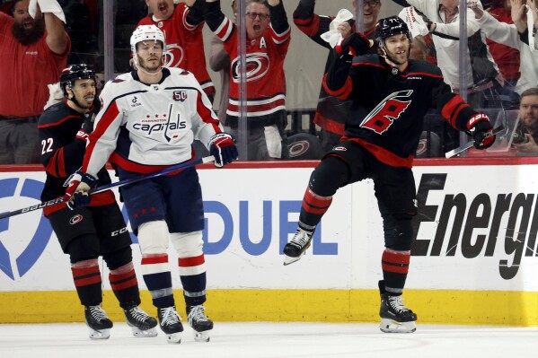 Carolina Hurricanes' Taylor Hall (71) celebrates after his goal with Washington Capitals' Matt Roy (3) nearby during the third period of Game 4 of second-round playoff series in Raleigh, N.C., Monday, May 12, 2025. (AP Photo/Karl DeBlaker)