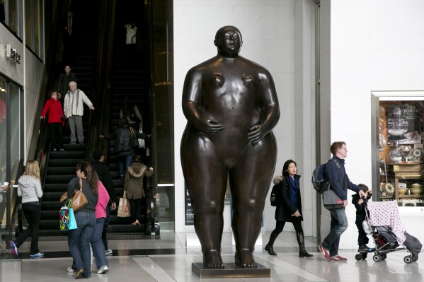FILE - Visitors to the Time Warner Center walk around the Fernando Botero sculpture titled Eve in New York, Oct. 30, 2013. Botero died on Sept. 15, 2023 in Monaco, according to his daughter Lina Botero who confirmed his passing to Colombian radio station Caracol. (AP Photo/Mark Lennihan, File)