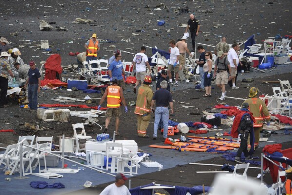FILE - A crowd gathers around debris after a P-51 Mustang airplane crashed at the Reno Air show, Friday, Sept. 16, 2011, in Reno Nev., killing former Hollywood stunt pilot Jimmy Leeward and 10 people on the ground. It was one of the deadliest air show disasters in U.S. history. Another 70 people were seriously injured. (Tim O'Brien/The Union via AP, File)